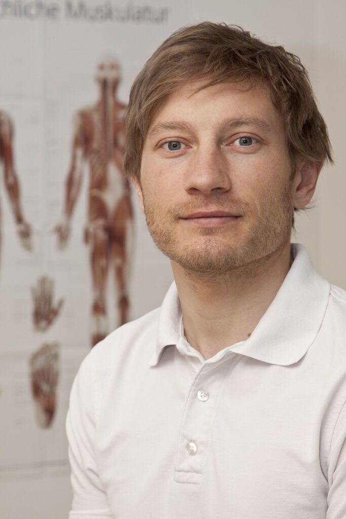 Christian Rzen Heilmasseur Gmunden Portrait vor Muskelplakat